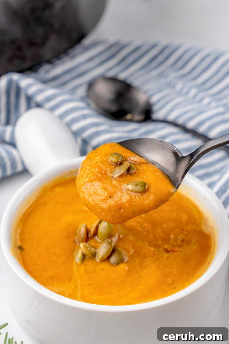 using a spoon to eat the soup.