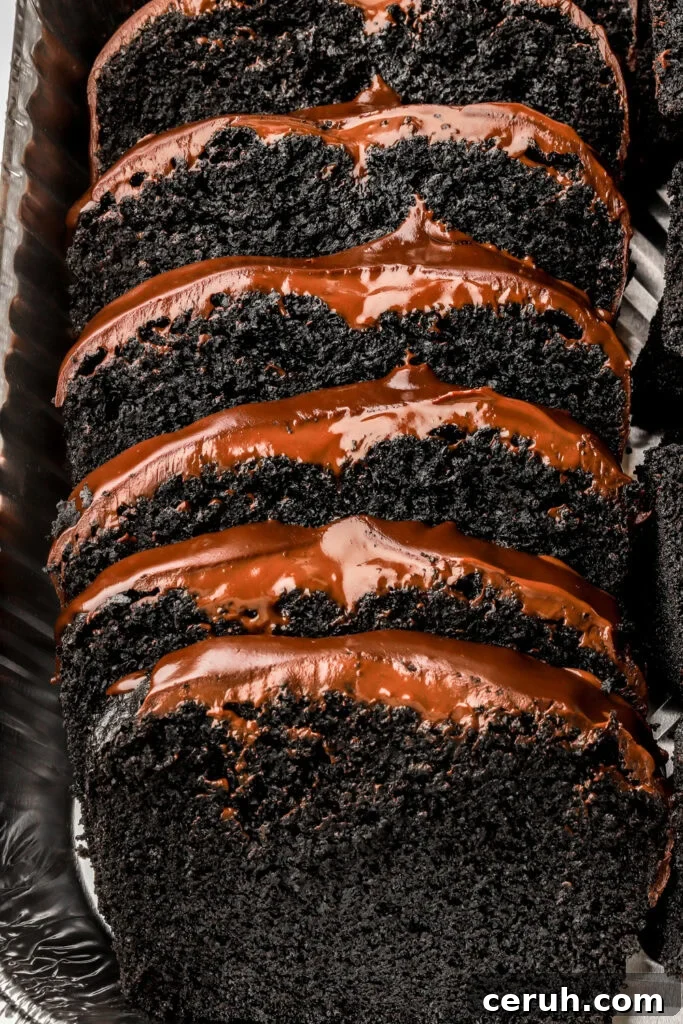 black cocoa loaf cake with chocolate ganache sliced in a pan