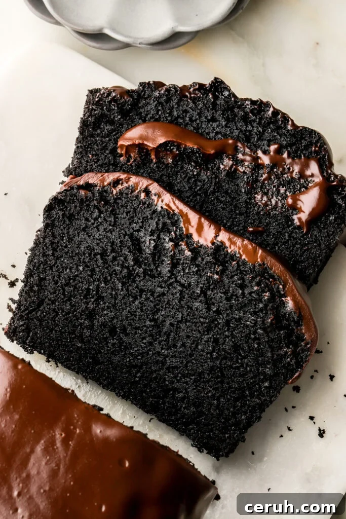 slice of black cocoa loaf cake with chocolate ganache