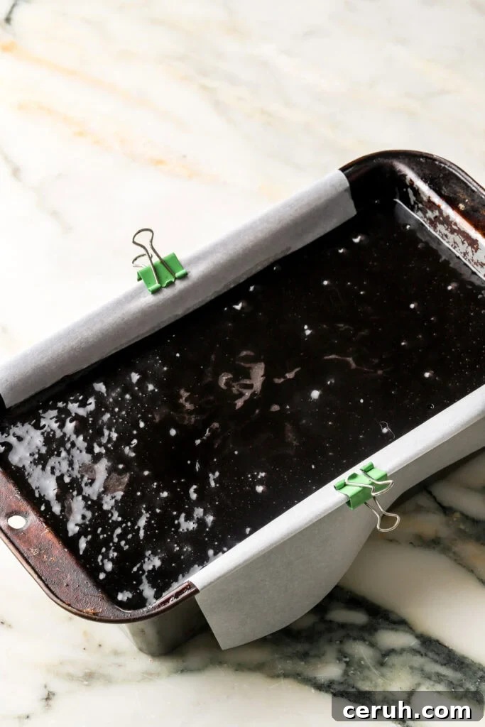 black cocoa cake batter poured into prepared loaf pan