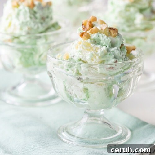 glass parfait dishes filled with pistachio salad, topped with chopped walnuts