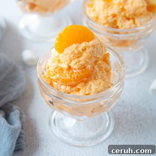 orange dreamsicle salad in glass parfait dishes, topped with mandarin oranges.