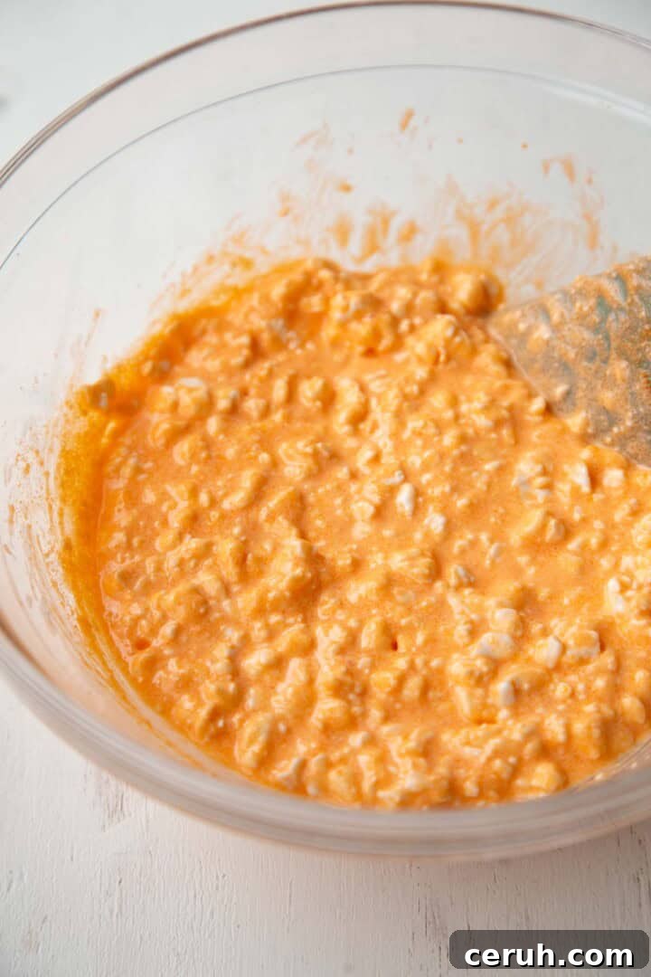cottage cheese and orange gelatin powder in a bowl.