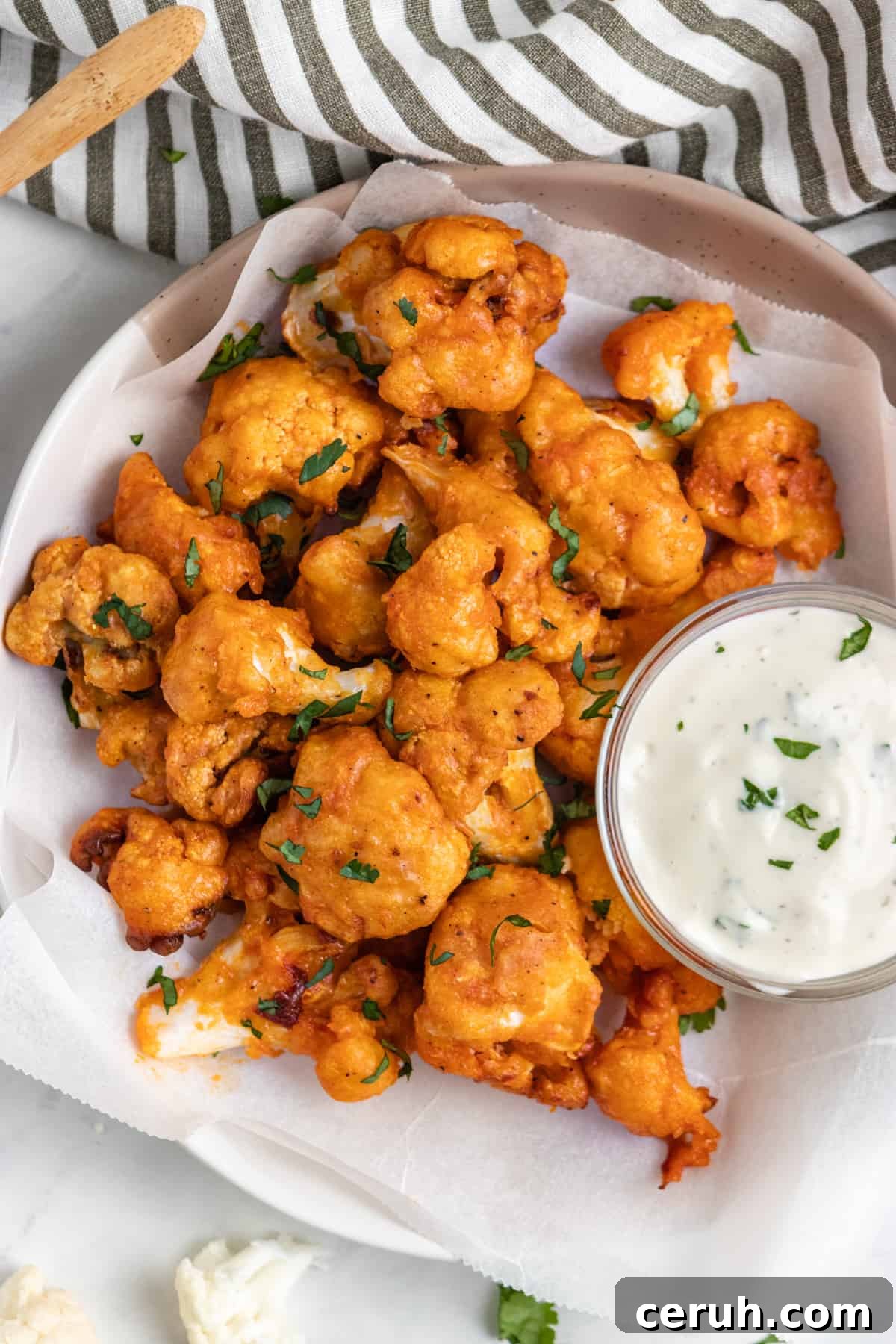 Overhead view of air fryer buffalo cauliflower with dip.