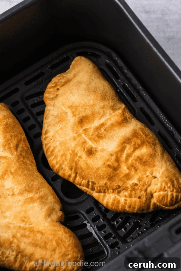 Close up of calzones in the air fryer basket.