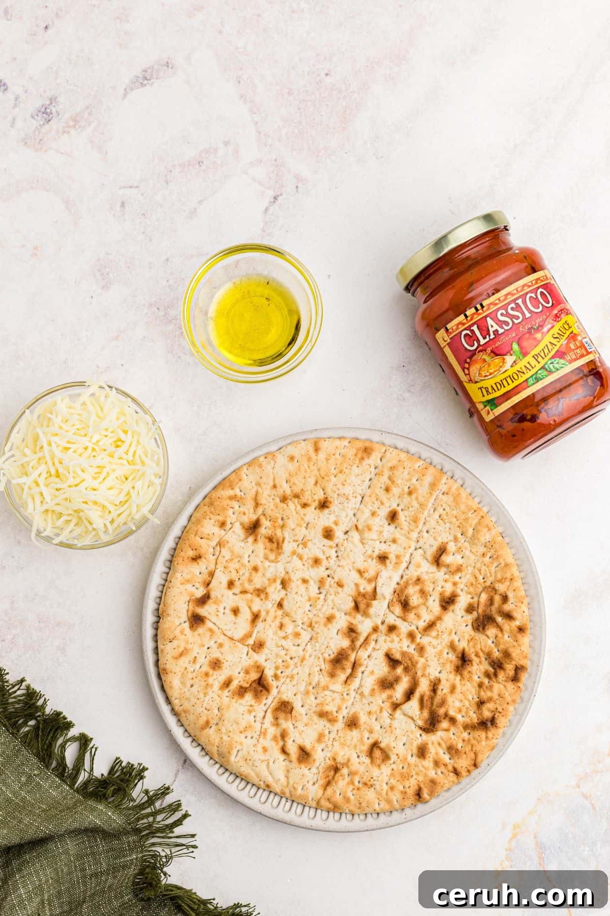 Ingredients needed to make air fryer pita pizza on a marble table. 