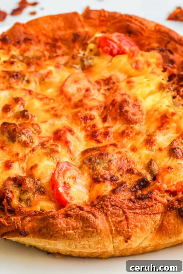 Breakfast pizza on a white plate ready to slice and serve.
