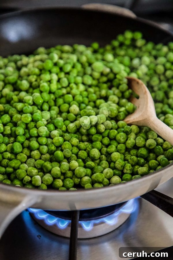 Spring Peas and Greens with Cacio e Pepe Dressing 5 peas cooking in a skillet