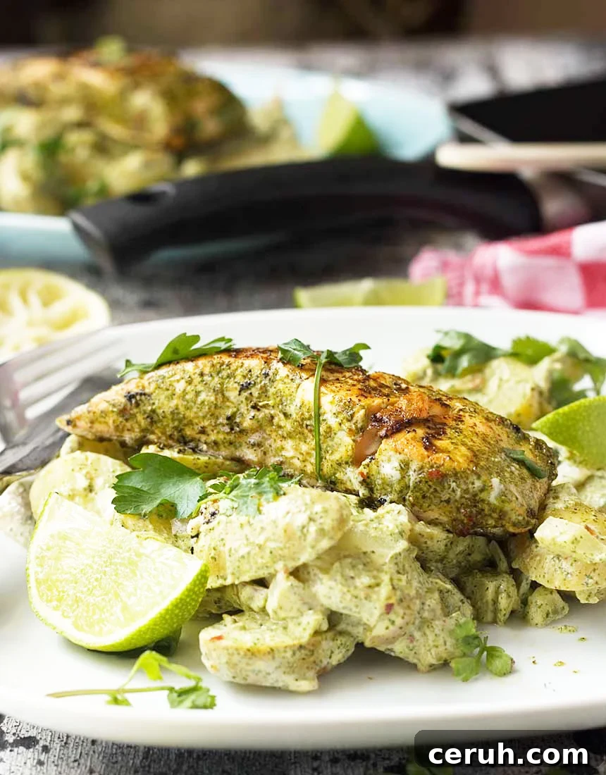 Jerk salmon with yoghurt potatoes and a lime wedge on a white plate.