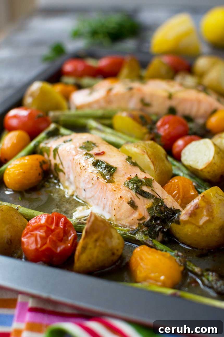 Lemon butter sheet pan salmon with asparagus and potatoes closeup on a baking tray.