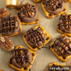 Rolo pretzel turtles drizzled in melted chocolate next to pecans on a baking sheet with parchment paper.