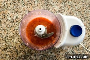Strawberries and syrup in a food processor after blending