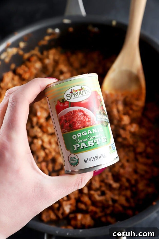 Photo of hand holding can of tomato paste