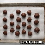 21 coconut truffles on a baking sheet.