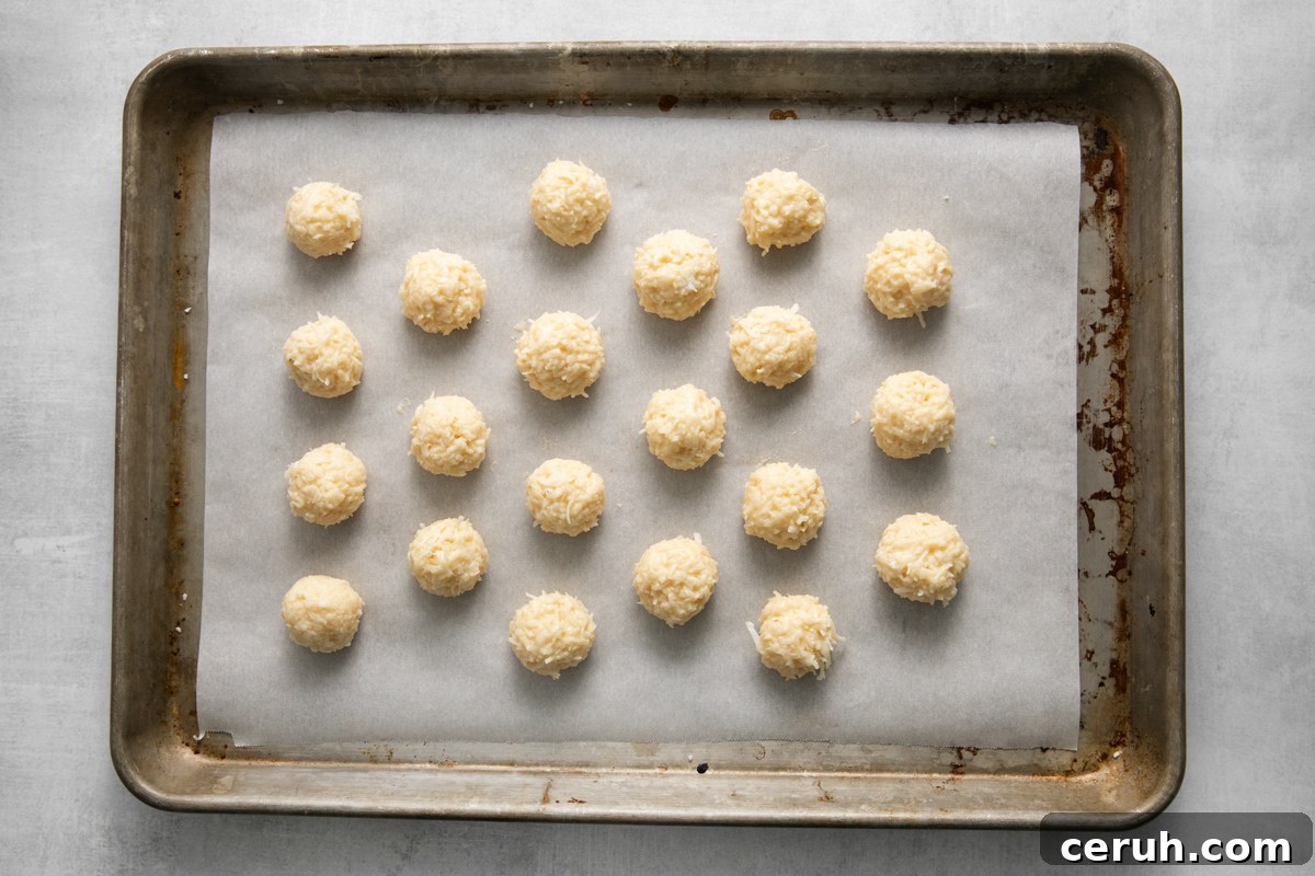 21 undipped coconut truffles on a baking sheet.
