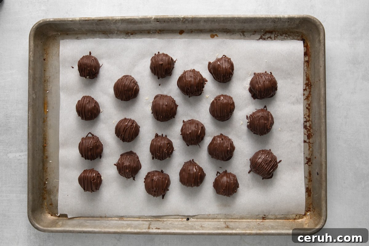 21 coconut truffles on a baking sheet.