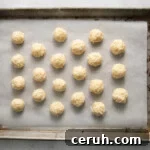 21 undipped coconut truffles on a baking sheet.