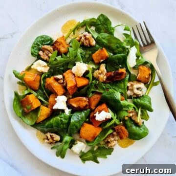 Fresh pumpkin salad on a white plate with a fork