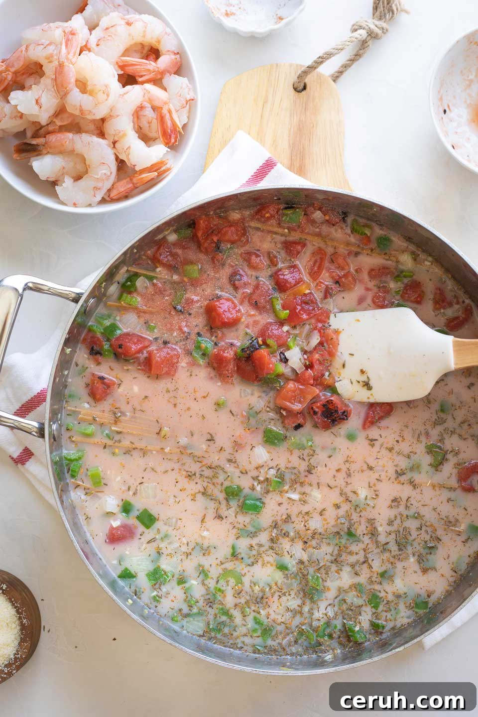 Stirring ingredients to submerge pasta in the liquids.