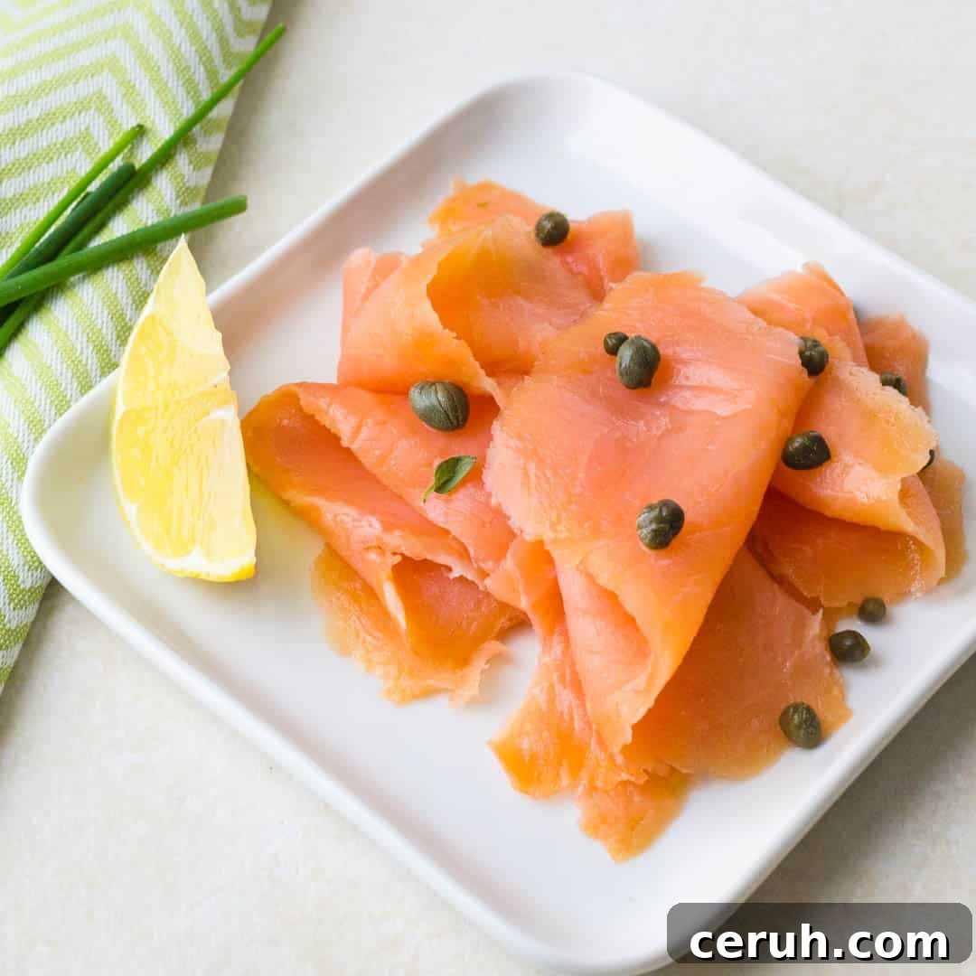 A plate of smoked salmon with capers and lemon.