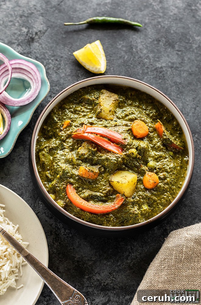 bowl of mixed vegetables in spinach curry and a plate of rice on the side