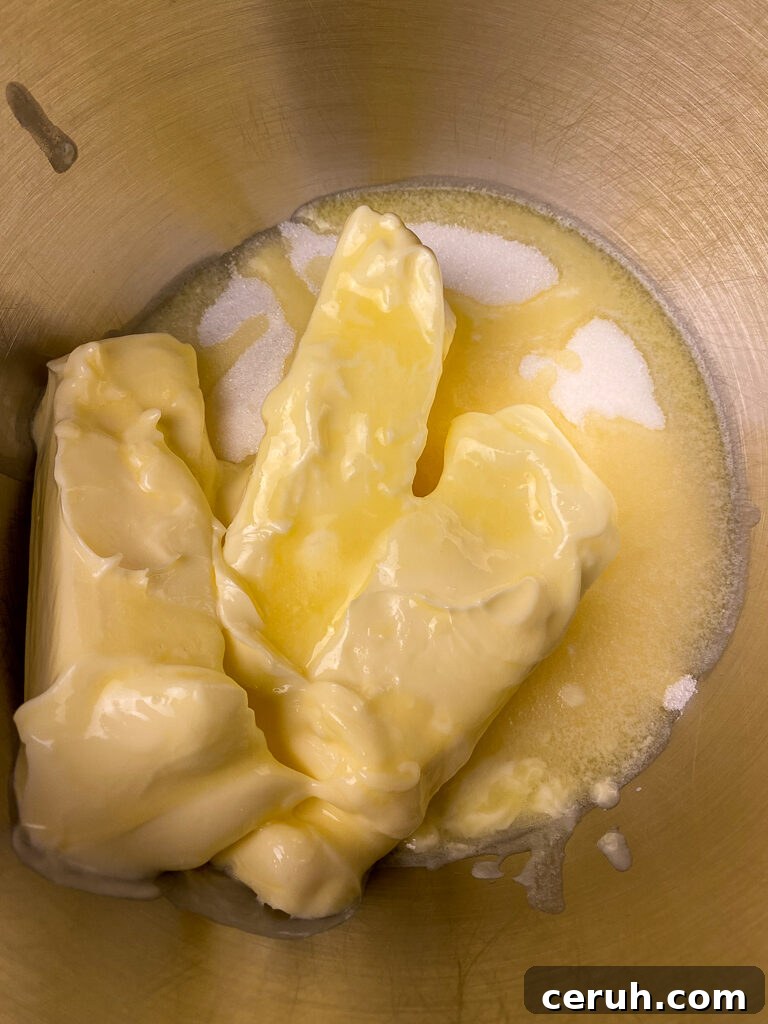 Softened butter on top of granulated sugar in a mixing bowl