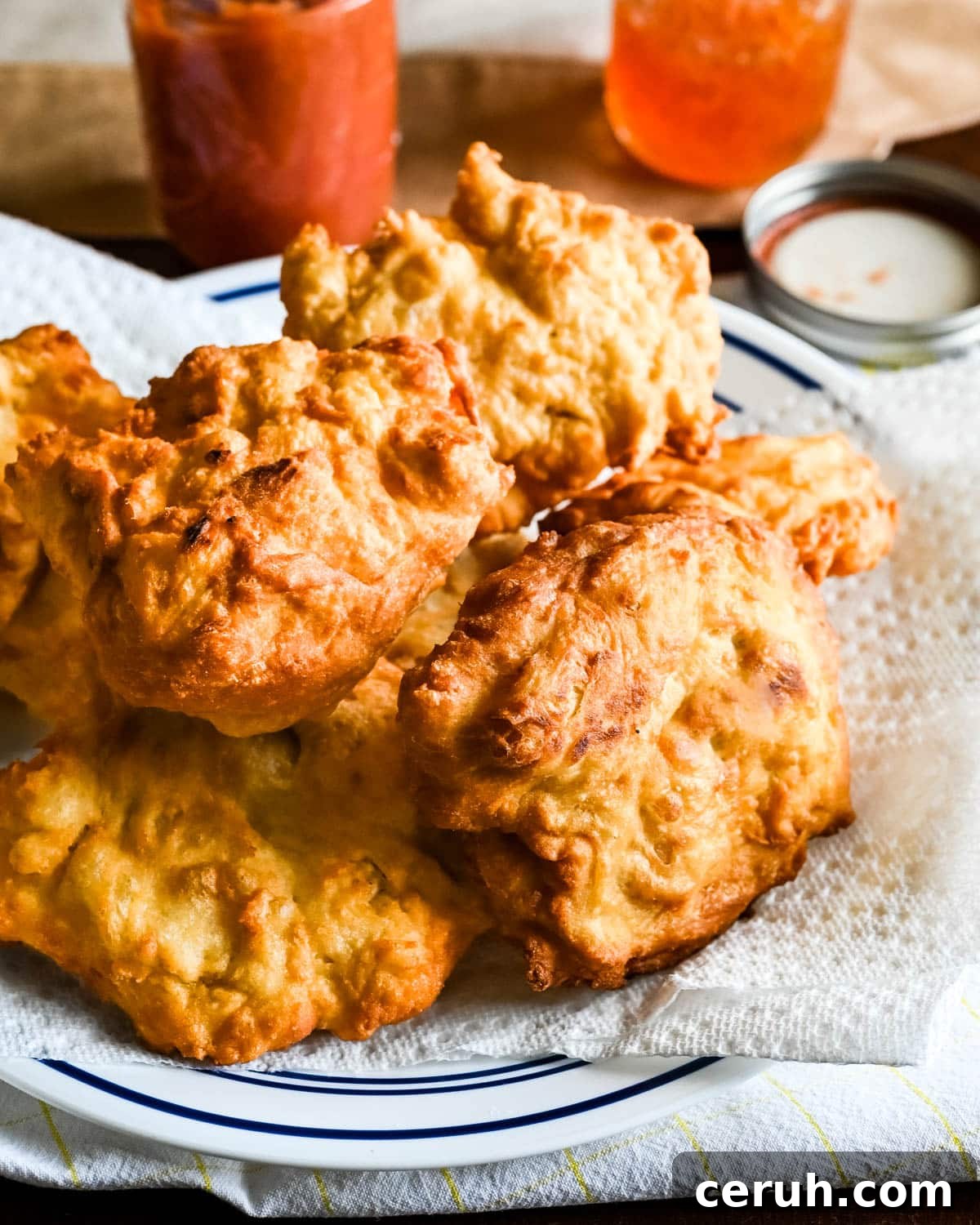 A platter of fried puffs on a plate lined with paper towels.