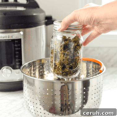 A picture of a hand placing a jar of cannabis inside an Instant pot for decarboxylation.