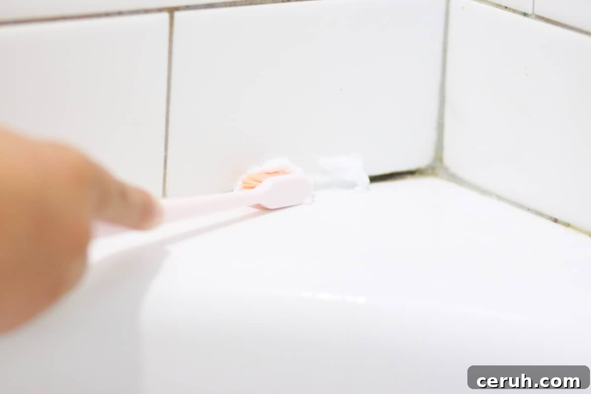 Natural Ways to Remove Mold from Shower Grout Quickly 6 mold in shower tile grout being cleaned with a toothbrush and a baking soda cleaning paste
