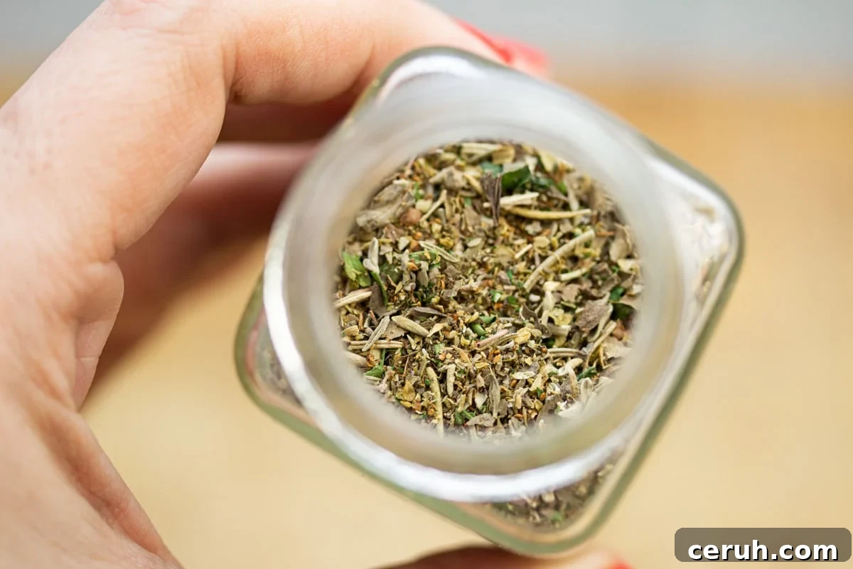 Holding a jar of homemade Italian seasoning blend.