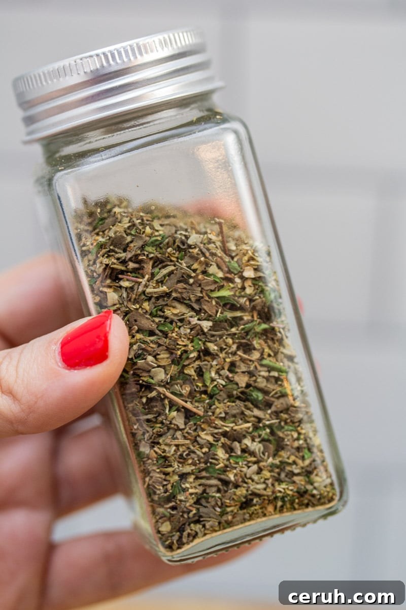 Holding a jar of homemade Italian seasoning blend.
