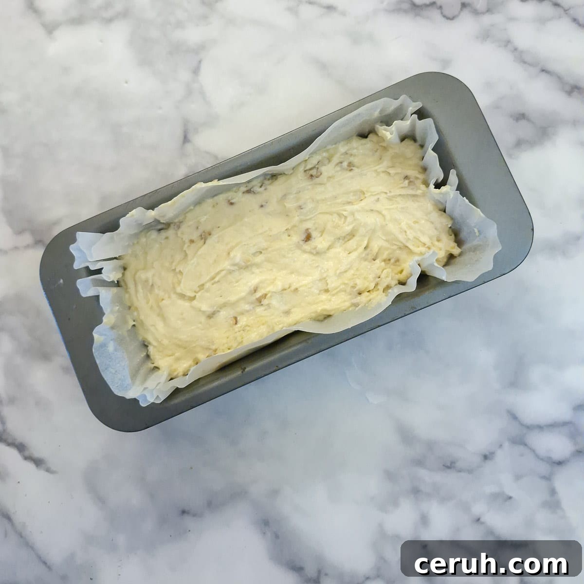 Orange Walnut Drizzle Cake with Zesty Citrus Glaze 9 Step 5, cake batter transferred into a lined loaf tin.