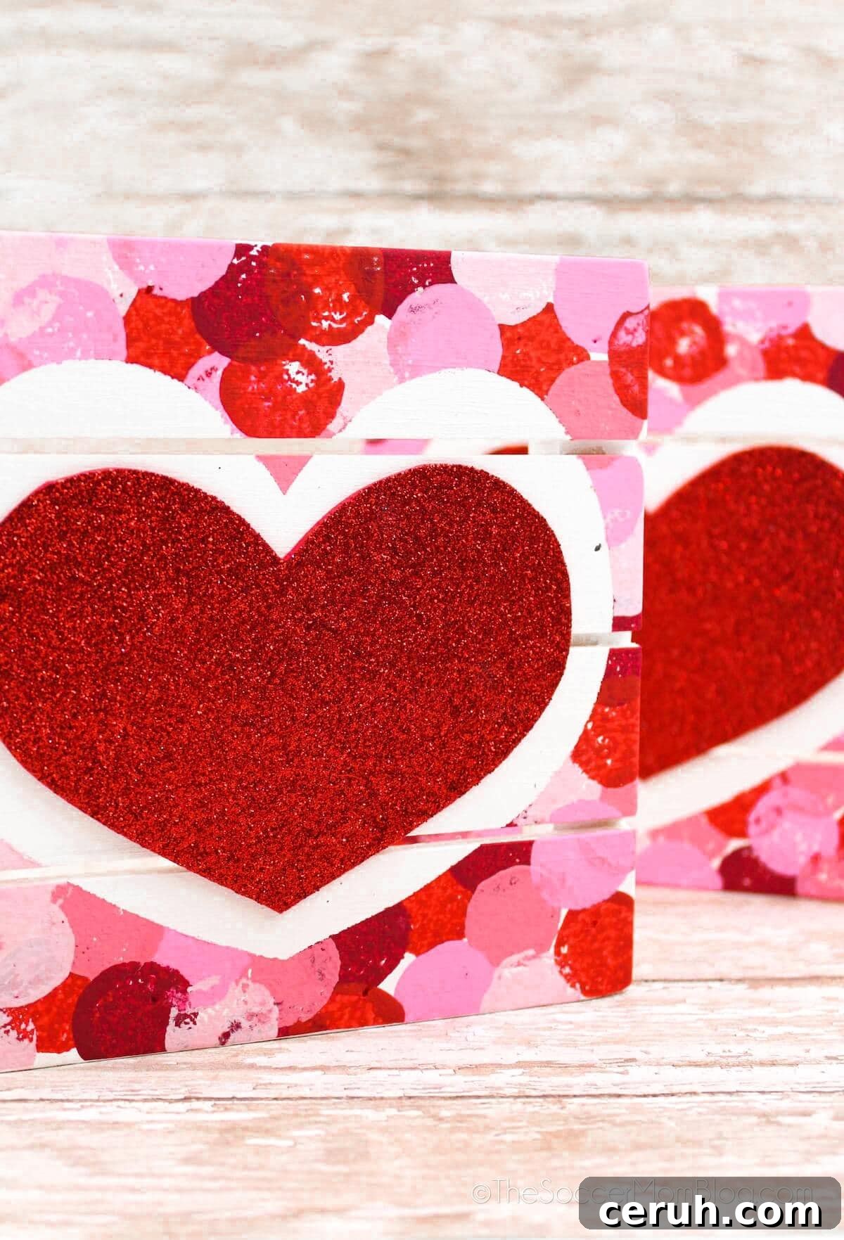 two Valentine painted coasters standing up.