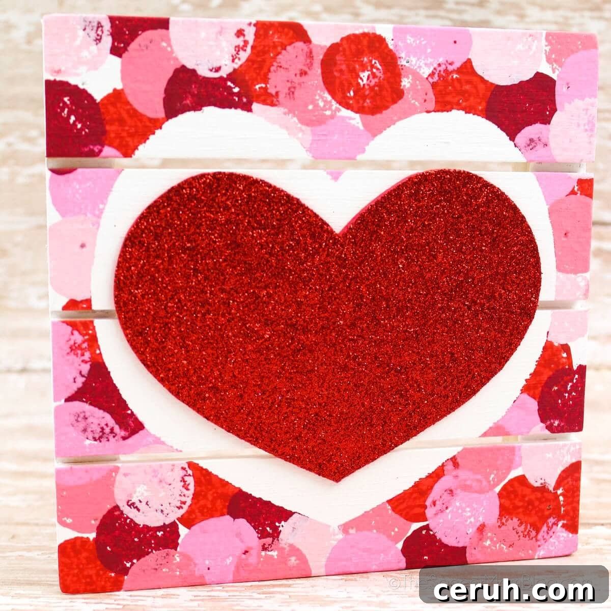 a mini wood pallet painted with a heart in the middle.