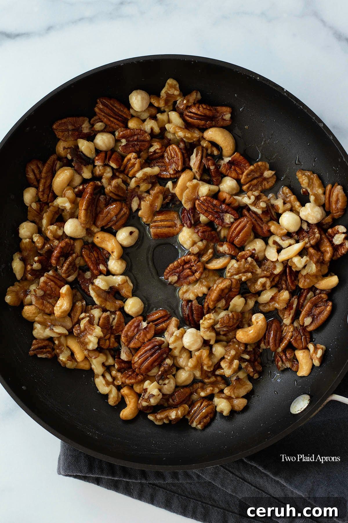 Nuts in a pan with sugar syrup.