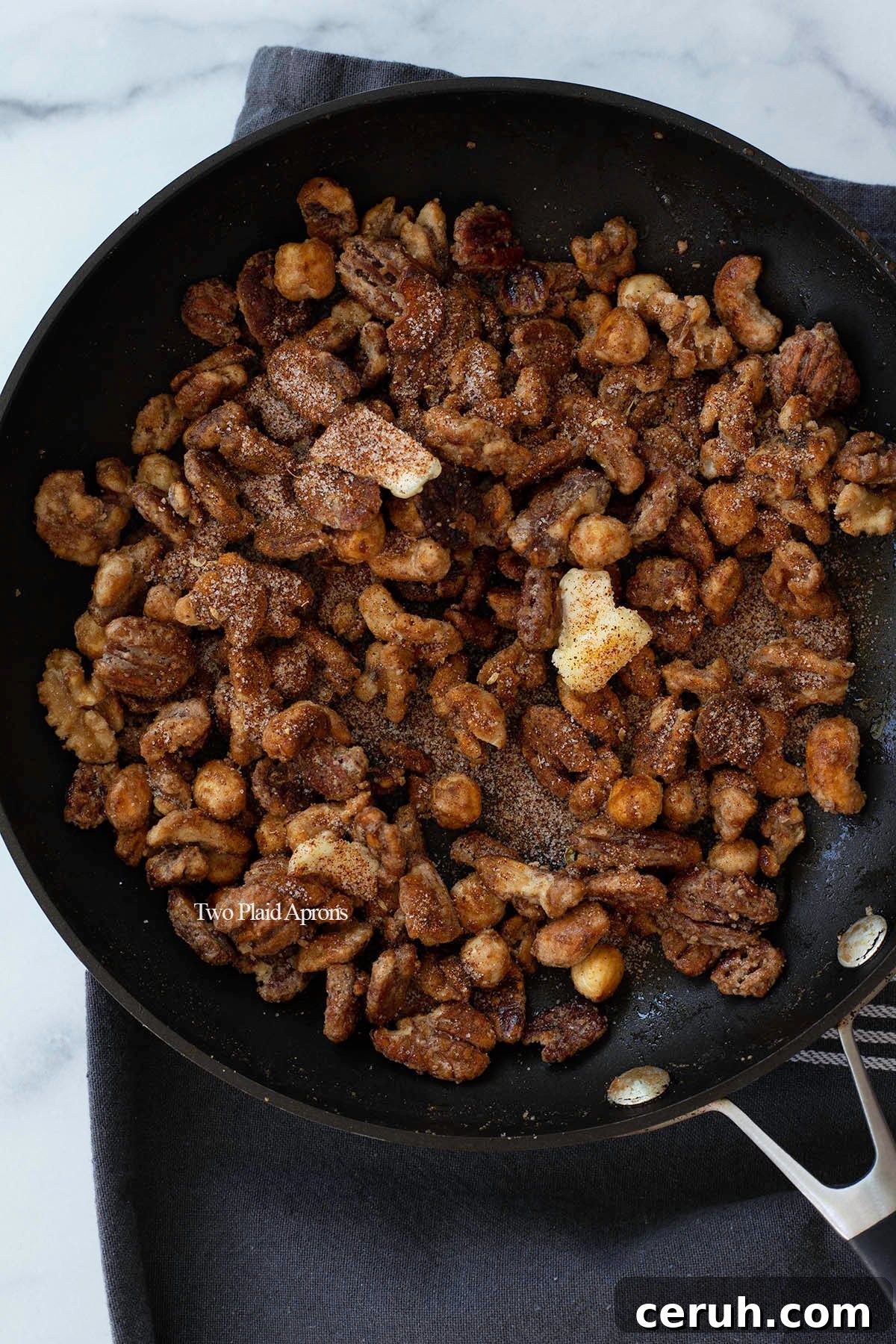 Spices and butter added to candied nuts.