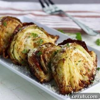 Air fried cabbage served on a white plate and garnished with fresh parsley and parmesan cheese
