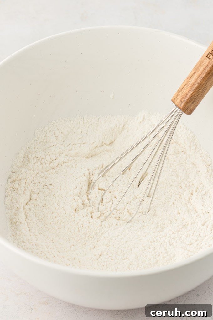 dry ingredients for buttermilk pancakes in a white bowl with a wire whisk