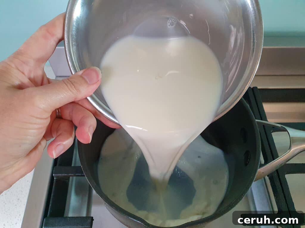 Adding milk to pot on stove.