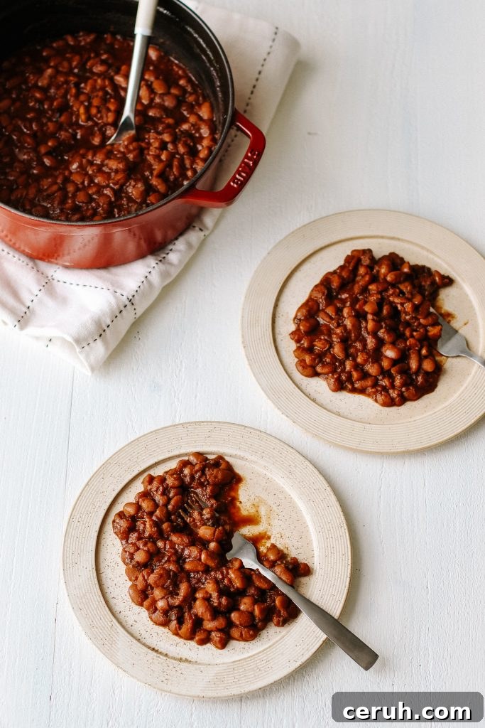 Vegan bbq baked beans on plate with fork and pot of beans