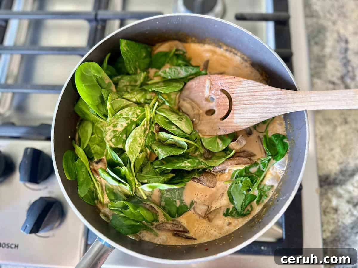 Creamy Butter Bean Curry with Coconut and Spinach 6 I added butter beans and spinach to the pan on the stove.