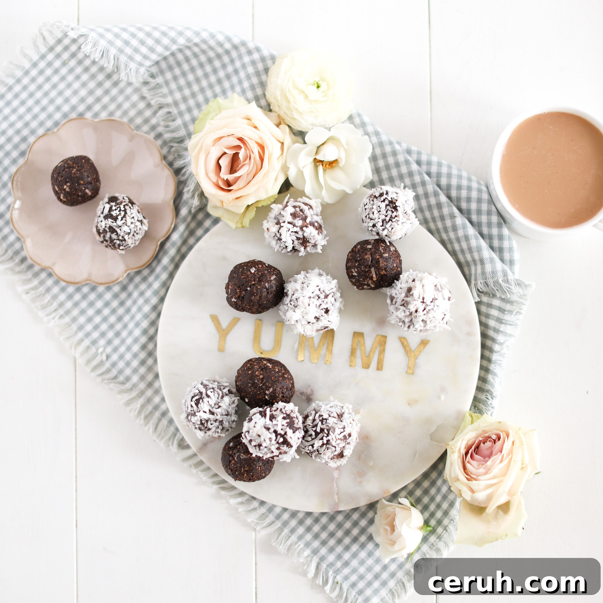 almond joy energy balls on a tray with cup of tea and flowers