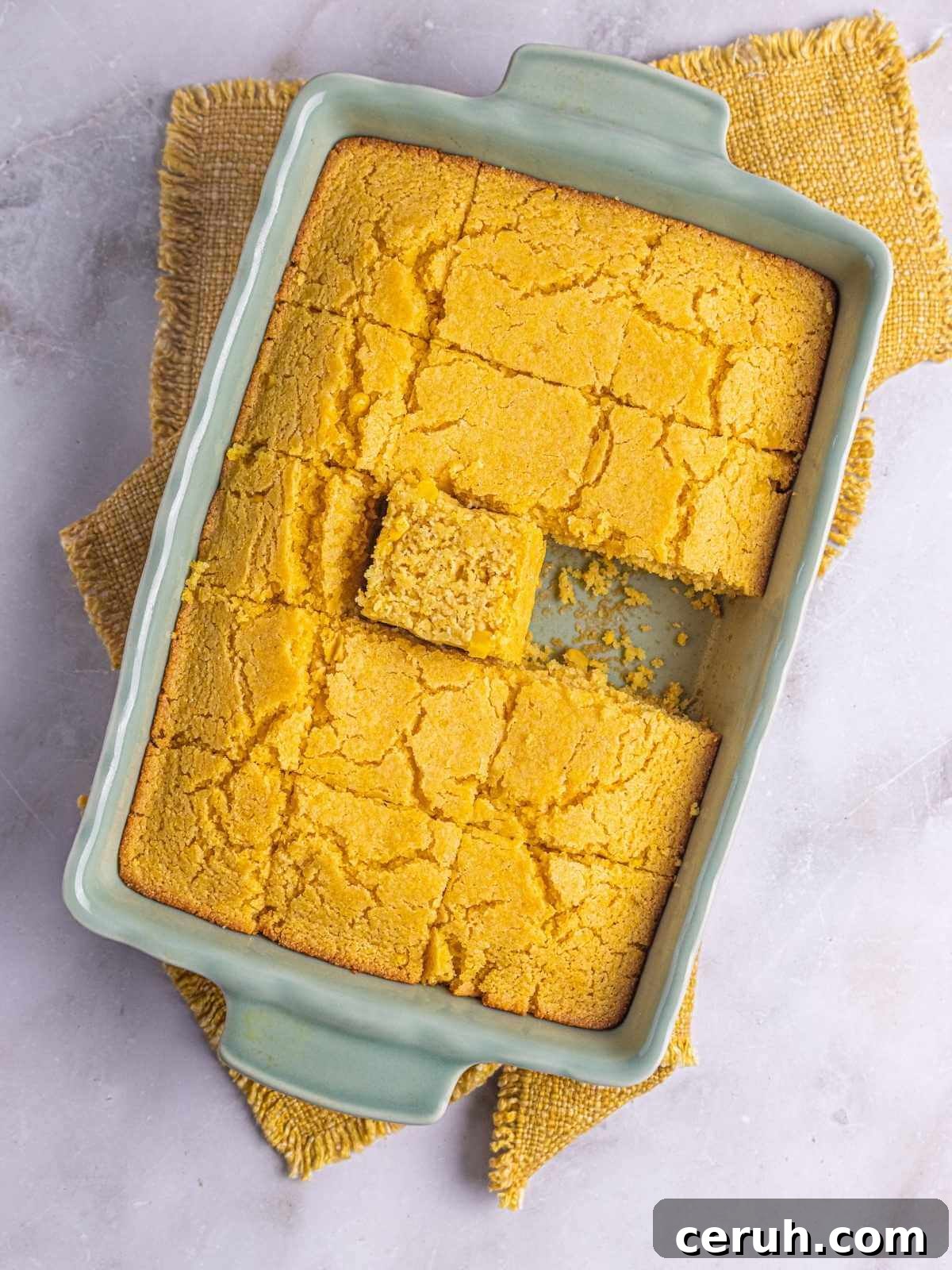 Cornbread cut into squares in a baking dish and ready to be served.