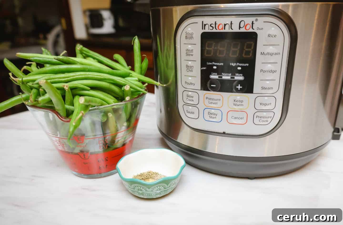 Fresh green beans measured beside an Instant Pot with thyme and seasoning, demonstrating how to cook Southern soul food green beans in a pressure cooker by The Soul Food Pot®.