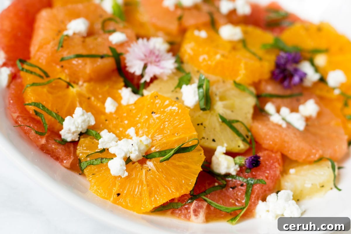 closeup of citrus salad with goat cheese on a white platter