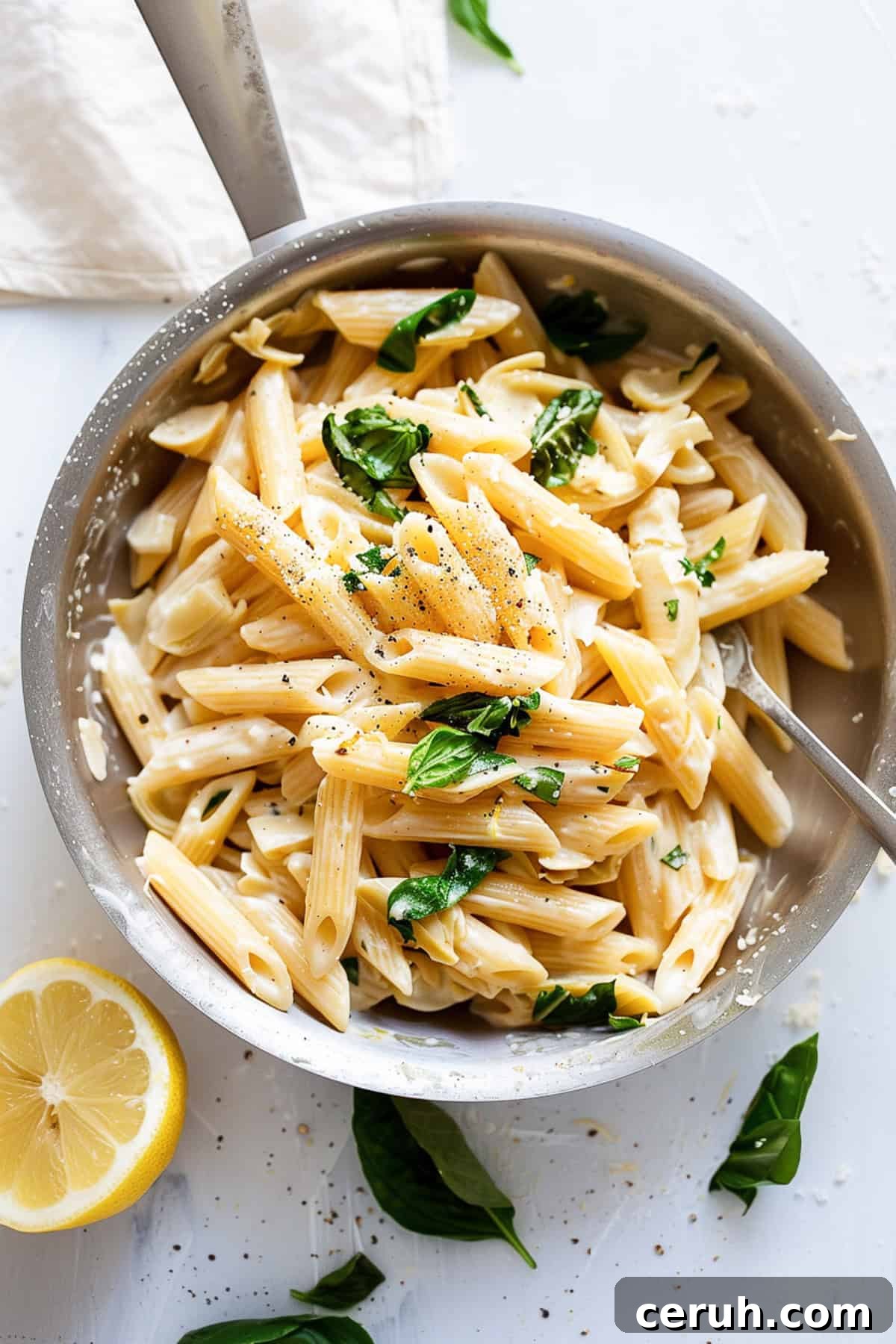 Lemon and artichoke pasta with spinach in a pan.