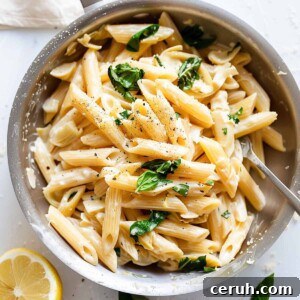 Lemon and artichoke pasta with spinach in a pan.