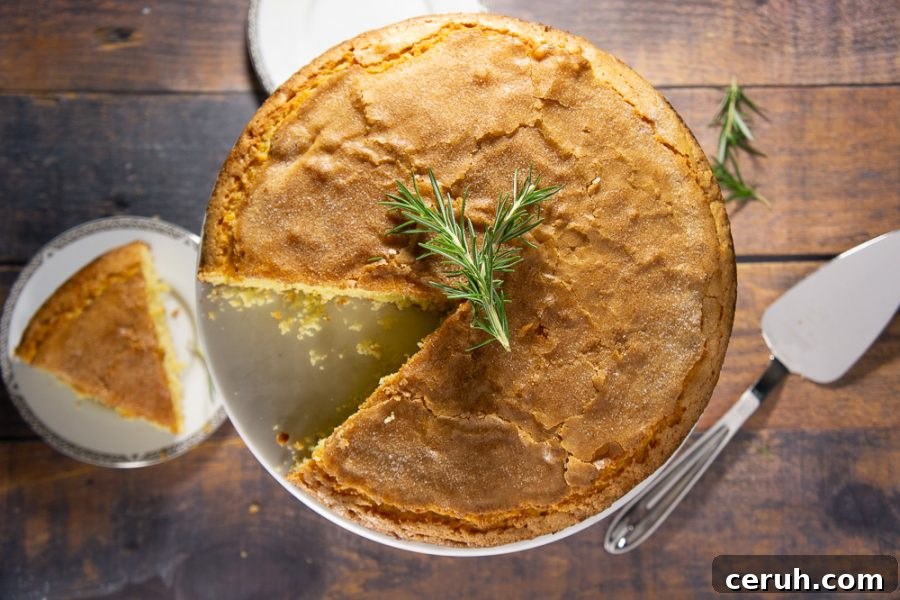 Classic Rosemary Olive Oil Cake Recipe for Moist, Fragrant Dessert 2 An olive oil cake with one slice cut out on a small plate
