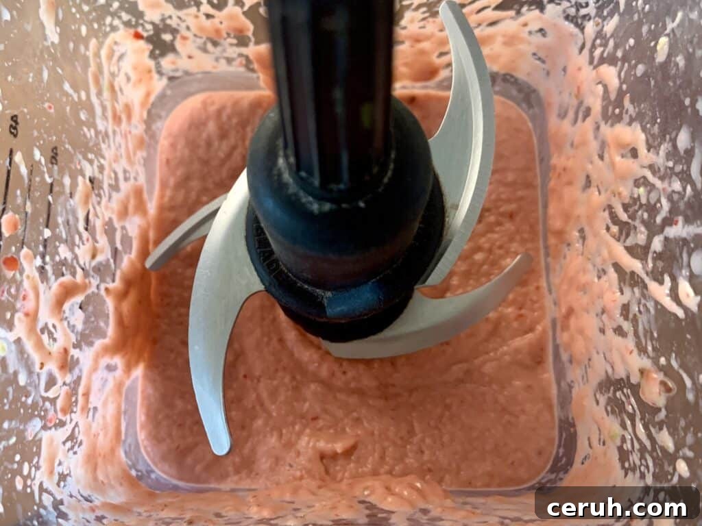 Top down view of a blender with keto strawberry avocado smoothie inside.