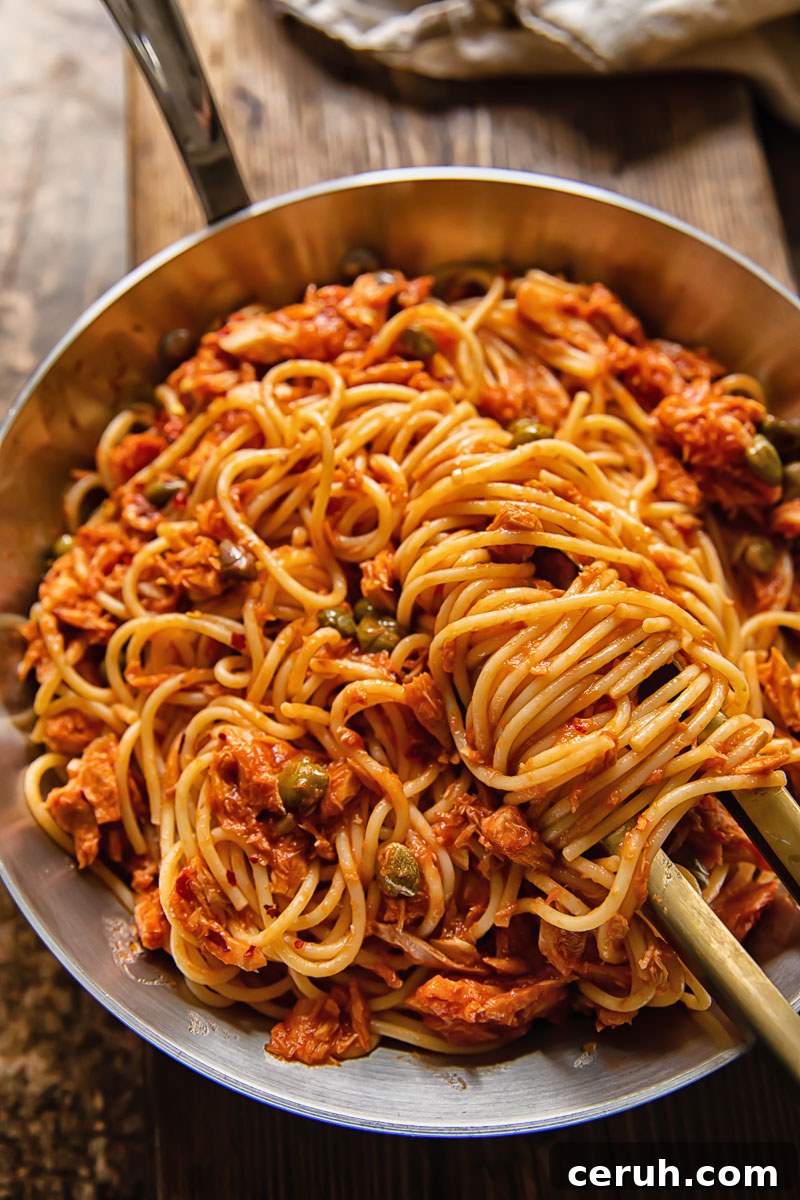 15-Minute Tuna Pasta with Capers and Lemon Zest 2 top down view of spaghetti in red sauce in a pan
